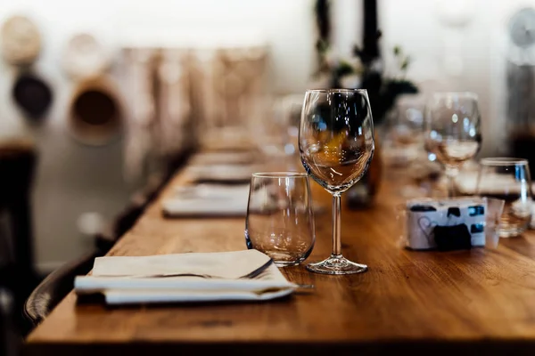 Luxury table settings for fine dining with and glassware, pouring wine to glass. Beautiful blurred background. Preparation for holiday wedding. Fancy luxury restaurant.