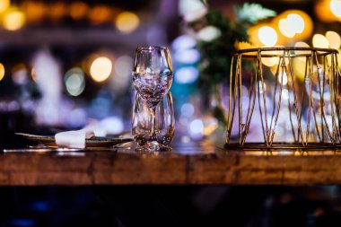 Şatafatlı yemek masaları ve cam eşyalar, bardağa şarap doldurmak. Güzel bulanık arkaplan. Tatil düğünü için hazırlık. Lüks bir restoran..