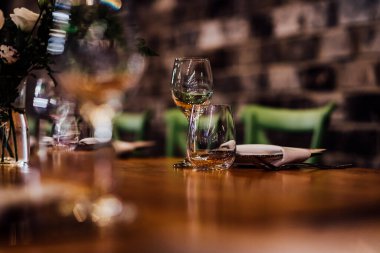 Şatafatlı yemek masaları ve cam eşyalar, bardağa şarap doldurmak. Güzel bulanık arkaplan. Tatil düğünü için hazırlık. Lüks bir restoran..