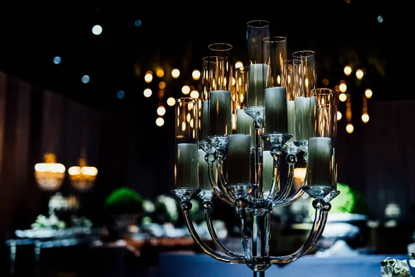 Şatafatlı yemek masaları ve cam eşyalar, bardağa şarap doldurmak. Güzel bulanık arkaplan. Tatil düğünü için hazırlık. Lüks bir restoran..