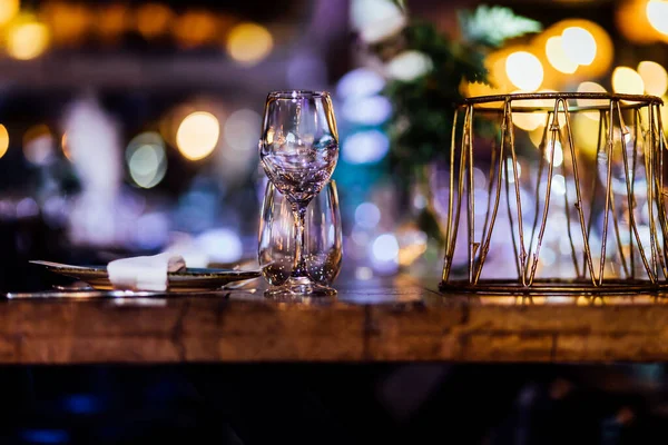 Şatafatlı yemek masaları ve cam eşyalar, bardağa şarap doldurmak. Güzel bulanık arkaplan. Tatil düğünü için hazırlık. Lüks bir restoran..
