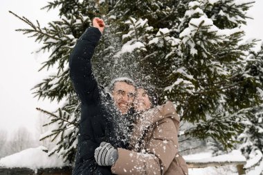 Kış yürüyüşüne çıkmış, kabarık ceketli sevimli bir çift. Erkek ve kadın soğuk ormanda eğleniyor. Kışın romantik bir randevu. Genç bir ailenin Noel havası. Kış aşkı hikayesi.