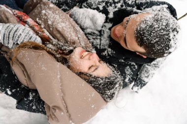 Kış yürüyüşüne çıkmış, kabarık ceketli sevimli bir çift. Erkek ve kadın soğuk ormanda eğleniyor. Kışın romantik bir randevu. Genç bir ailenin Noel havası. Kış aşkı hikayesi.