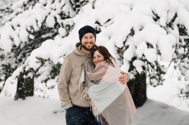 Kışın yürü. Kucaklaşan çift kar yağışı yapıyor. Erkek ve kadın soğuk ormanda eğleniyor. Kışın romantik bir randevu. Genç bir ailenin Noel havası. Aşk ve eğlence konsepti