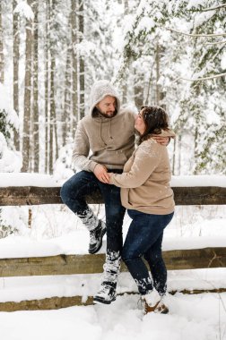 Kışın yürü. Kucaklaşan çift kar yağışı yapıyor. Erkek ve kadın soğuk ormanda eğleniyor. Kışın romantik bir randevu. Genç bir ailenin Noel havası. Aşk ve eğlence konsepti
