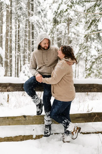 Kışın yürü. Kucaklaşan çift kar yağışı yapıyor. Erkek ve kadın soğuk ormanda eğleniyor. Kışın romantik bir randevu. Genç bir ailenin Noel havası. Aşk ve eğlence konsepti