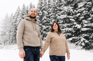 Kışın yürü. Kucaklaşan çift kar yağışı yapıyor. Erkek ve kadın soğuk ormanda eğleniyor. Kışın romantik bir randevu. Genç bir ailenin Noel havası. Aşk ve eğlence konsepti