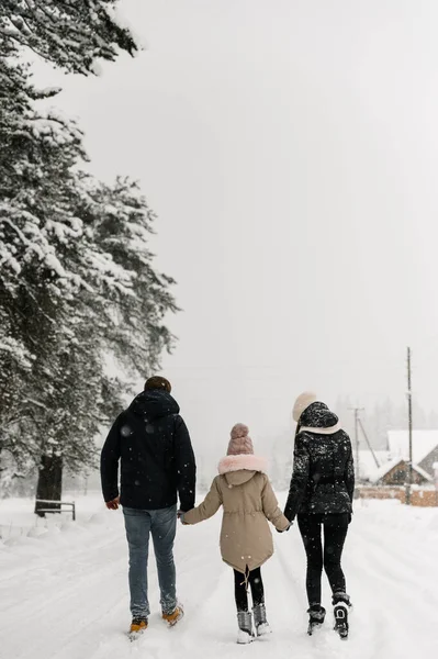 Mutlu aile kış ormanlarında eğleniyor. Anne, baba ve kızı karla oynuyorlar. Birlikte vakit geçirmenin tadını çıkarıyorlar. Aile kavramı