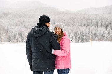 Kış yürüyüşüne çıkmış, kabarık ceketli sevimli bir çift. Buz gibi ormanda poz veren kadın ve erkek. Kışın romantik bir randevu. Genç bir ailenin Noel havası. Kış aşkı hikayesi.