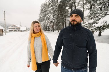 Çekici bir adam ve kadın soğuk ormanda sarılıyorlar. Kazaklı yetişkin bir çift yürüyüş yaparken eğleniyor. Kış zamanı romantik bir tarih. Kış aşk hikayesi.