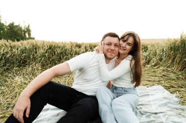 Genç bir çift gün batımında bir tarlanın ortasında bir yatak örtüsüne oturur. Sevgililer romantik bir buluşmada iletişim kurar. Buğday tarlasında insanlar.