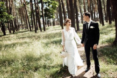 Aşıklar doğada olmak için sarılırlar. Gelin ve damat ormanda yürüyorlar. düğün çifti