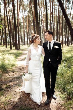 Aşıklar doğada olmak için sarılırlar. Gelin ve damat ormanda yürüyorlar. düğün çifti