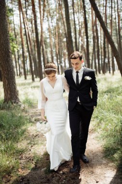 Aşıklar doğada olmak için sarılırlar. Gelin ve damat ormanda yürüyorlar. düğün çifti