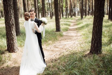 Evlilik gününde çılgın mutlu çift, düğün gününde iki kişilik yürüyüş, damadı bozkırda çılgın gelin, damat gelininin elini tutuyor.