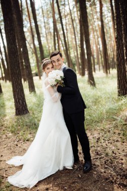 Damat gelini kucaklıyor. Genç bir çiftin düğün günü. Aşıklar ormanda yürür