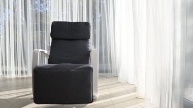 Modern bir sallanan sandalye geniş bir odada duruyor. rahat koltuklar