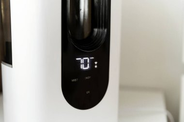 Hava nemlendirici yatağın yanındaki komodinin üzerindeki odada. Kablosuz ağ ve uzaktan kumandalı akıllı nemlendirici. elektronik kontrol paneli.
