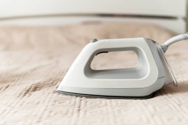 Kıyafetleri ekolojik modda ütülemek için akıllı buhar jeneratörü. Ev işi konsepti. Modern demir yatağın üstünde..