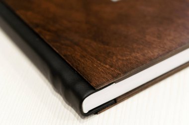Güzel ve şık modern bir ahşap fotoğraf kitabı bir masanın üzerinde duruyor. Hafıza için fotoğraf albümü. kumaş kitap kapağı