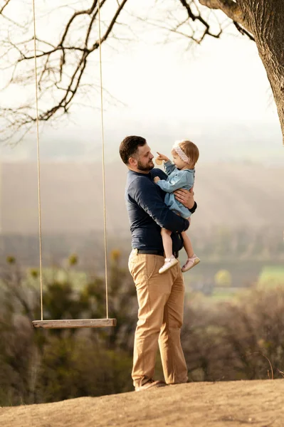 Pai Bonito Com Uma Barba Brinca Com Sua Filhinha Balanço — Fotografia de Stock