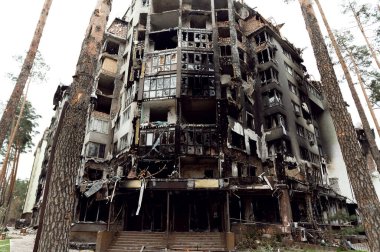 Roket saldırısı sonucu yanmış bir ev. Rus işgali Ukrayna 'da. Rusya 'nın Ukrayna' ya karşı savaşı. Ukrayna 'daki çok katlı binayı yok etti. Evde büyük bir yangın var. yanmış araba