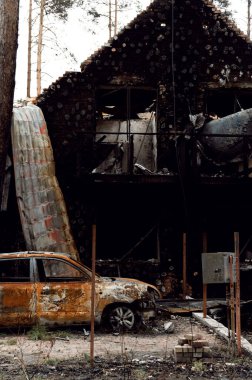 burned house from a rocket attack. Russian invasion of Ukraine. Russia's war against Ukraine. destroyed multi-storey building in ukraine. big fire in the house. burnt car