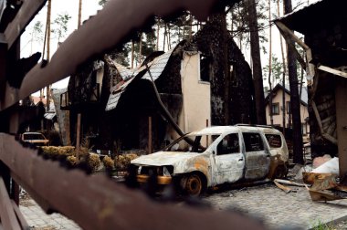 burned house from a rocket attack. Russian invasion of Ukraine. Russia's war against Ukraine. destroyed multi-storey building in ukraine. big fire in the house. burnt car