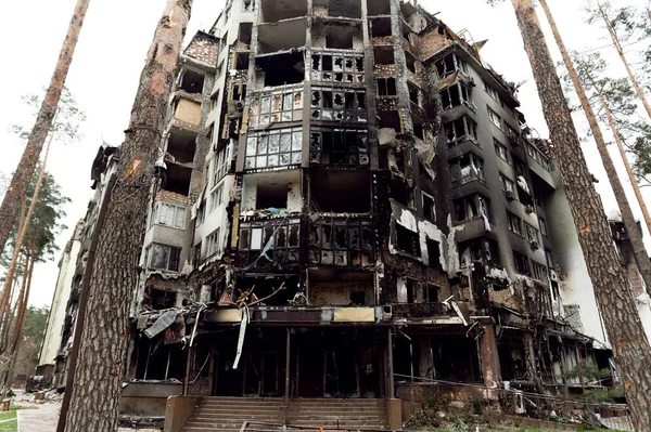 Roket saldırısı sonucu yanmış bir ev. Rus işgali Ukrayna 'da. Rusya 'nın Ukrayna' ya karşı savaşı. Ukrayna 'daki çok katlı binayı yok etti. Evde büyük bir yangın var. yanmış araba