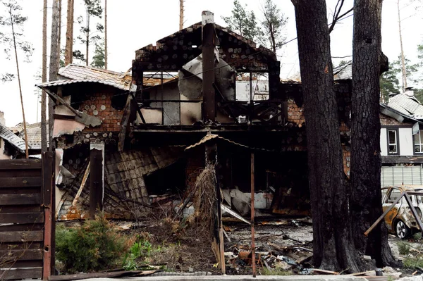 Roket saldırısı sonucu yanmış bir ev. Rus işgali Ukrayna 'da. Rusya 'nın Ukrayna' ya karşı savaşı. Ukrayna 'daki çok katlı binayı yok etti. Evde büyük bir yangın var. yanmış araba