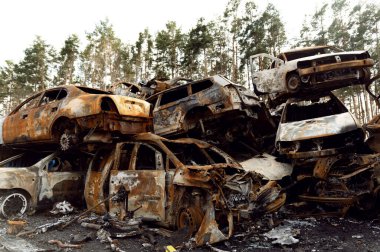 Paslı, yanmış arabalar roket patlamalarıyla yok edildi. Bomba parçaları parçalanmış arabalar. Ukrayna 'da Rus vandalizmi. Ukrayna 'da savaş. Kyiv, Bucha ve Irpen 'de tahrip edilen arabalar.