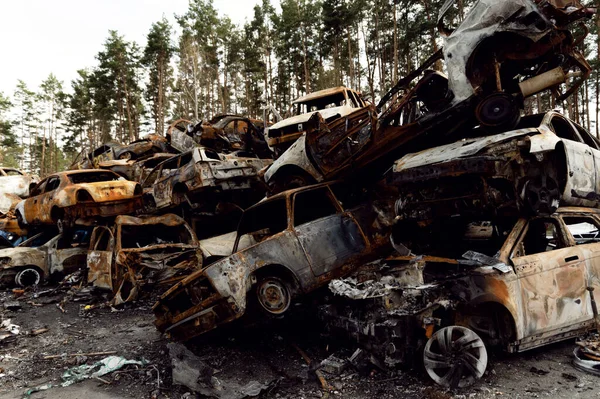 Paslı, yanmış arabalar roket patlamalarıyla yok edildi. Bomba parçaları parçalanmış arabalar. Ukrayna 'da Rus vandalizmi. Ukrayna 'da savaş. Kyiv, Bucha ve Irpen 'de tahrip edilen arabalar.