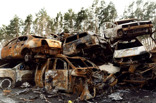 Paslı, yanmış arabalar roket patlamalarıyla yok edildi. Bomba parçaları parçalanmış arabalar. Ukrayna 'da Rus vandalizmi. Ukrayna 'da savaş. Kyiv, Bucha ve Irpen 'de tahrip edilen arabalar.