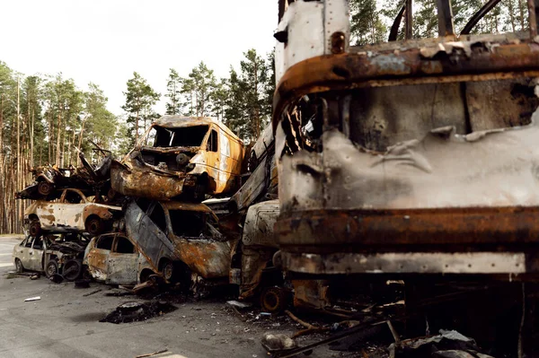 Ukraynalı adam Rus füzelerinden etkilenen kırık ve yanmış arabaların arka planında duruyor. Arabaları boşaltın. Adam bozuk arabalara bakıyor. Bomba parçaları delikleri. Ukrayna 'da savaş