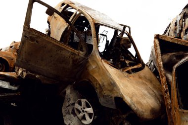 Paslı, yanmış arabalar roket patlamalarıyla yok edildi. Bomba parçaları parçalanmış arabalar. Ukrayna 'da Rus vandalizmi. Ukrayna 'da savaş. Kyiv, Bucha ve Irpen 'de tahrip edilen arabalar.