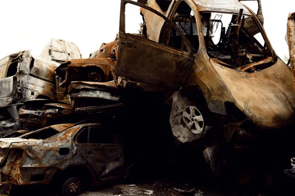 Paslı, yanmış arabalar roket patlamalarıyla yok edildi. Bomba parçaları parçalanmış arabalar. Ukrayna 'da Rus vandalizmi. Ukrayna 'da savaş. Kyiv, Bucha ve Irpen 'de tahrip edilen arabalar.