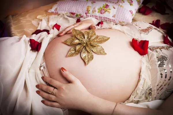 Belle femme enceinte au lit à la maison tenant ventre. Grossesse. Joyeux enceinte fille dans la chambre — Photo