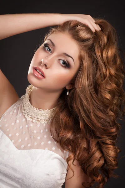 Mulher de moda de cabelo vermelho com cabelo longo encaracolado pele perfeita e maquiagem em vestido branco. Menina com corte de cabelo elegante. Produtos de saúde e beleza. Cuidado com a pele. Spa. Modelo de beleza — Fotografia de Stock