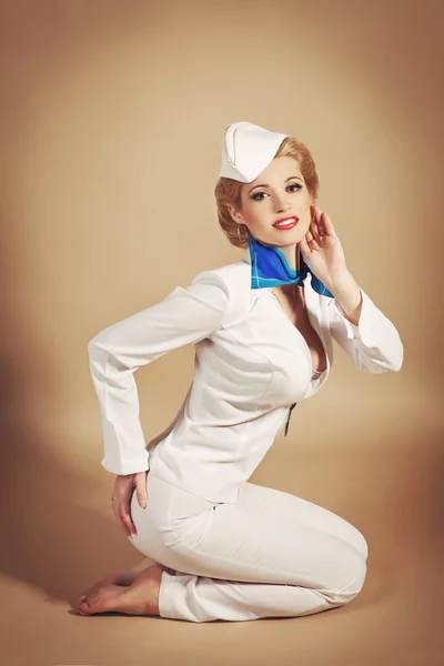 Mujer rubia seductora en pin-up traje de marinero retro con maquillaje brillante y peinado. Beaotiful chica azafata — Foto de Stock