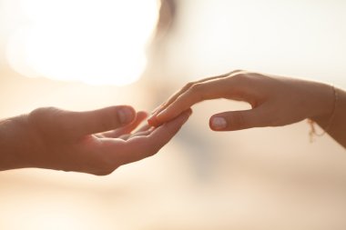 Çift holding düğün günbatımı üzerinde eller.