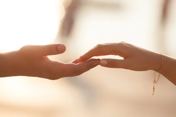 Çift holding düğün günbatımı üzerinde eller.