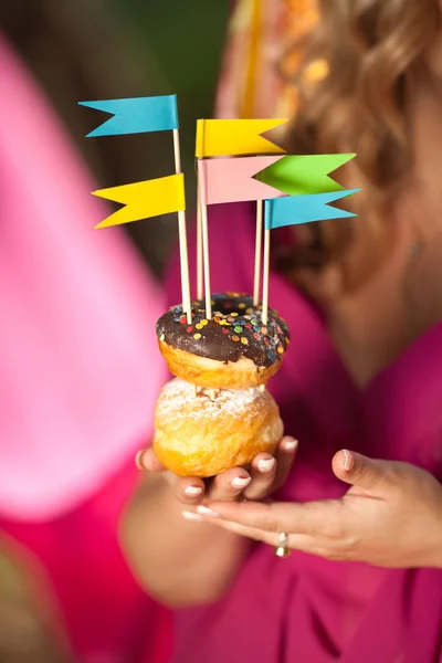 Hamile kadın holding renkli donut. — Stok fotoğraf