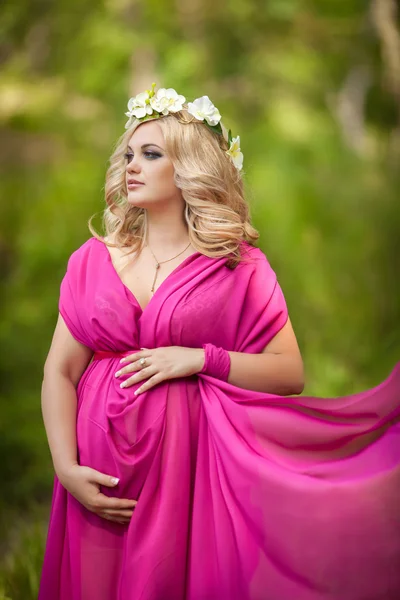 Aantrekkelijke zwangere vrouw over aard, zwangerschap meisje. — Stockfoto