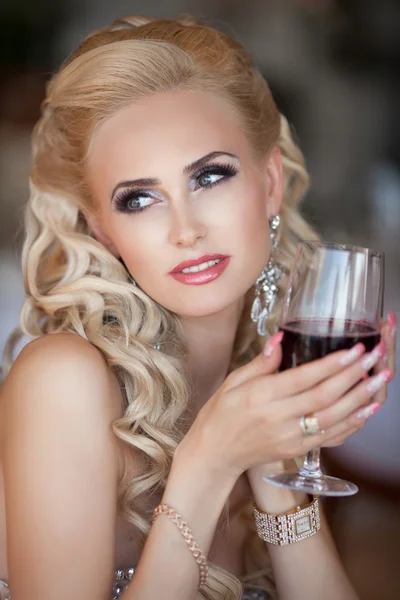 Underbara blonda kvinnan med rött vin glas i lyx restaurang. — Stockfoto