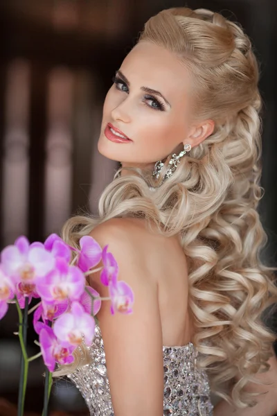güzel sarışın genç kadın orkide çiçek buketi ile.