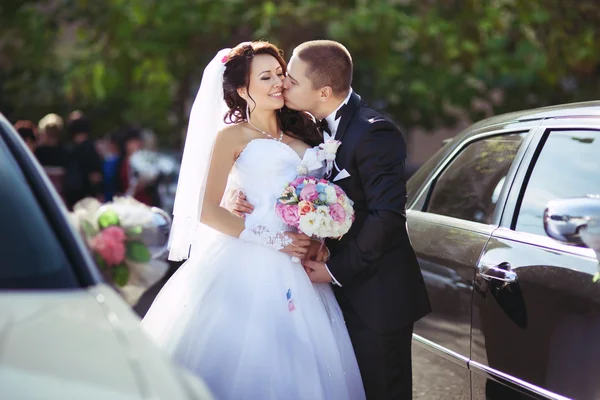 Groom and beautiful bride near car — Stock Photo, Image