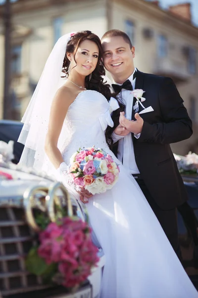 Bruidegom en mooie bruid in de buurt van auto — Stockfoto