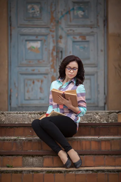 Красивая женщина читает книги на улице — стоковое фото