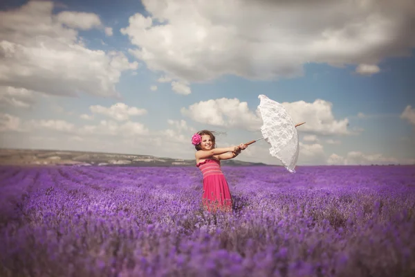 Meisje met paraplu in lavendel weide — Stockfoto