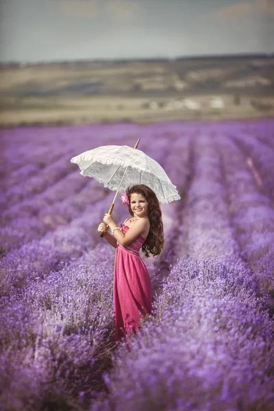 Девушка с зонтиком на лавандовом лугу — стоковое фото